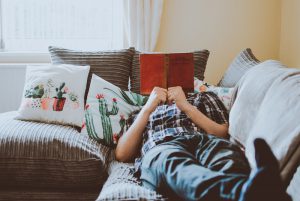 a person lying on a sofa while reading a book, sober living los angeles, couples sober living, sober living house los angeles