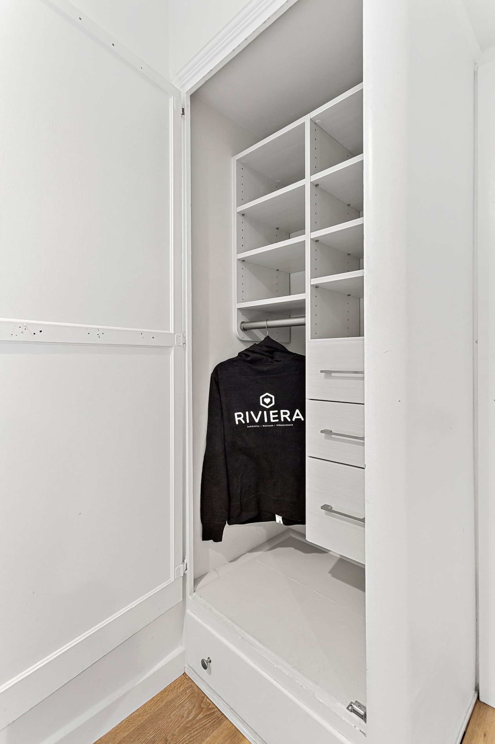 closet with cubbies and Riviera sweatshirt on a rack