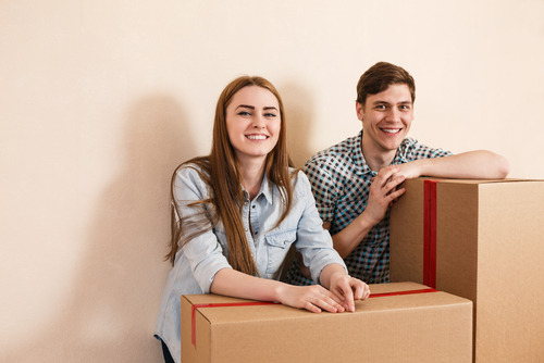 young adults sitting on boxes while moving into their independent housing